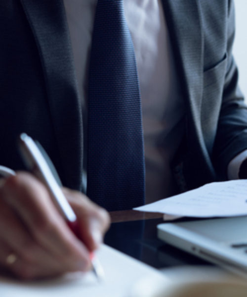 Main d'un homme signant un document